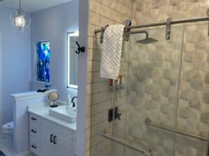 Sleek, modern bathroom featuring a spacious walk-in shower with stylish tiles and a rain showerhead. A contemporary vanity and elegant lighting complete the space.